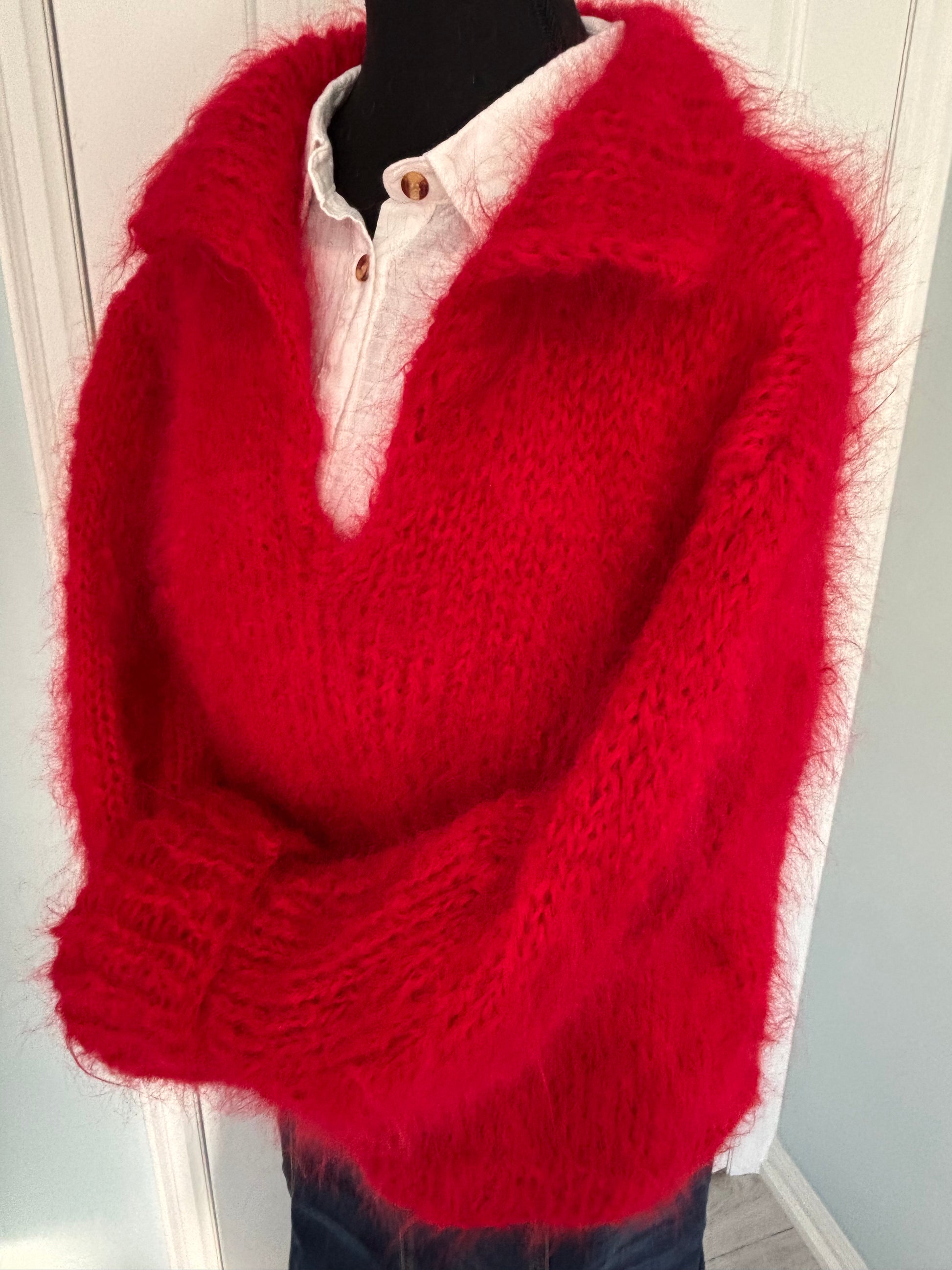 Red knitted sweater on a white surface