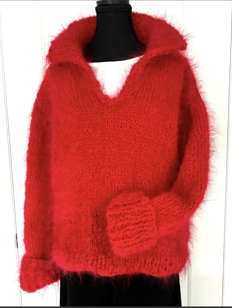 Red knitted sweater on a mannequin against a white background